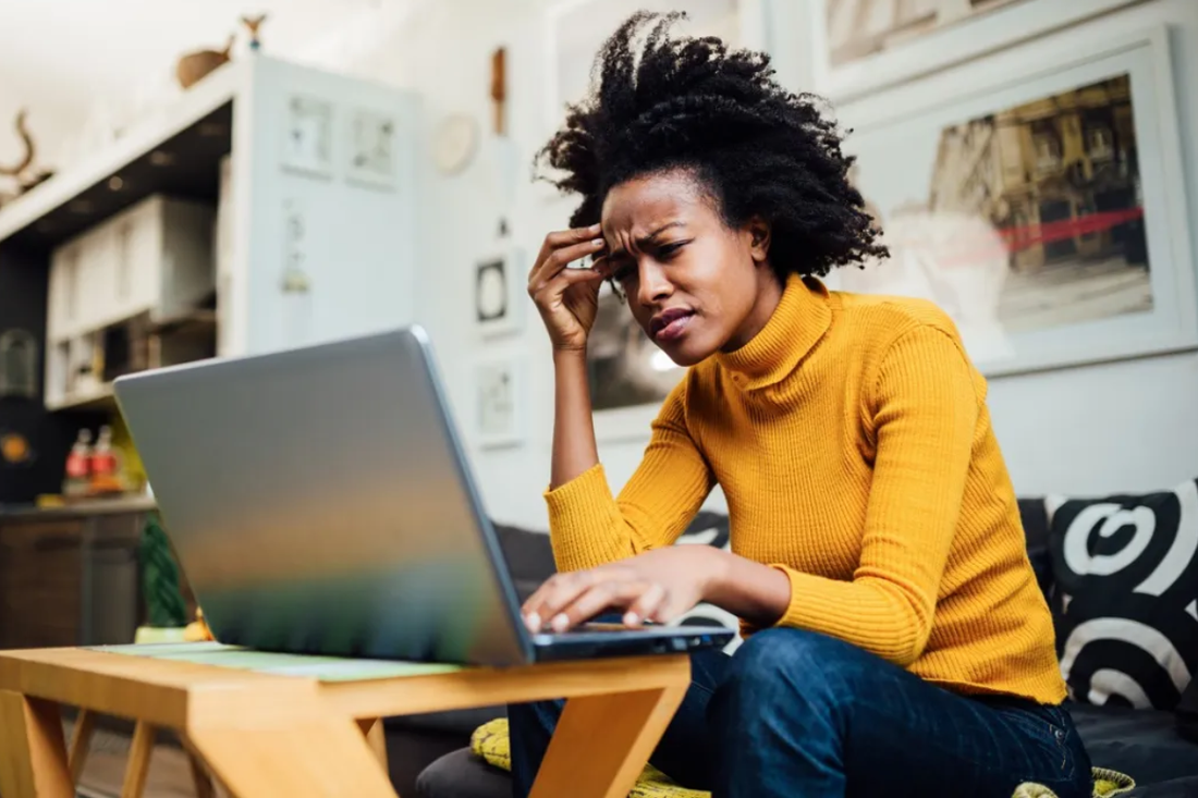 Women sitting at a laptop looking up the First Signs of Perimenopause Starting