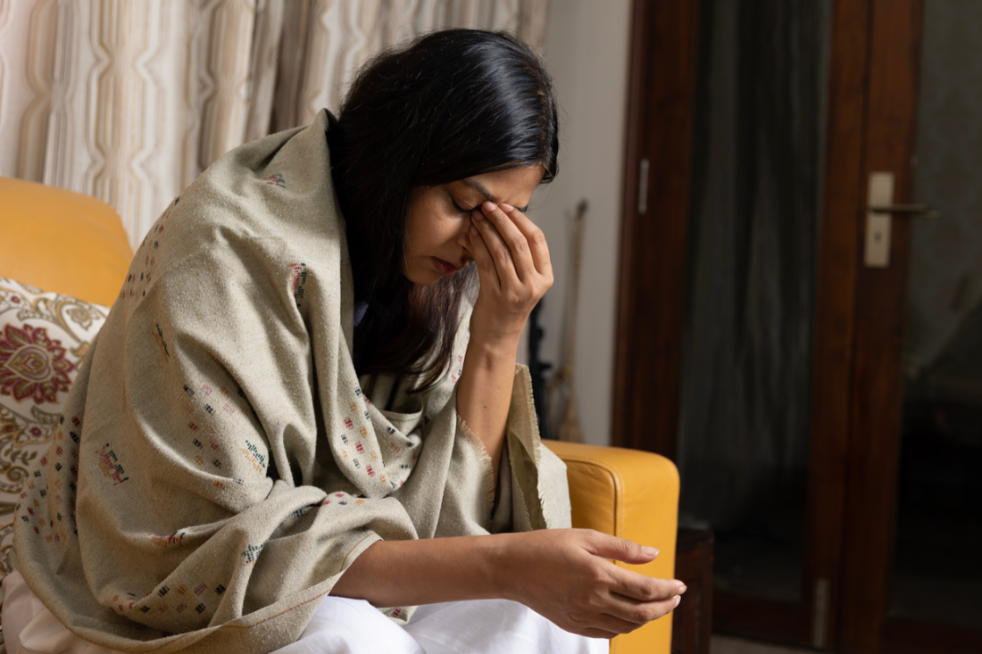 Midlife woman exhausted and anxious from hormone disruption caused by the Estrogen-Mitochondria Axis